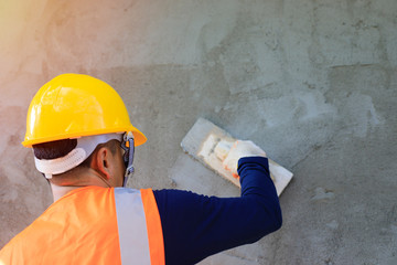 Workers plastering the wall indoors,Workers on the construction site, construction sites against...