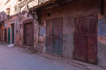 Fototapeta na wymiar Small street in Marrakech's medina old town. In Marrakech the houses are traditionally pink. Morocco