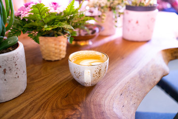 Cup of hot cappucino on the wooden table.