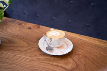 Cup of hot cappucino on the wooden table.