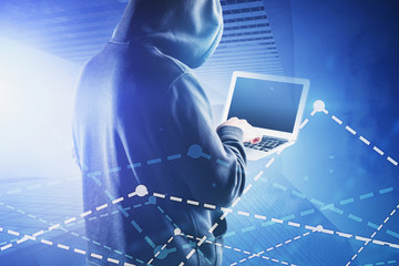 Hacker with laptop in city, graphs