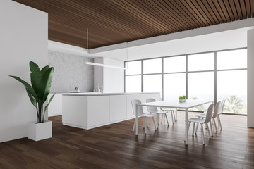 White and wooden kitchen corner, table and island