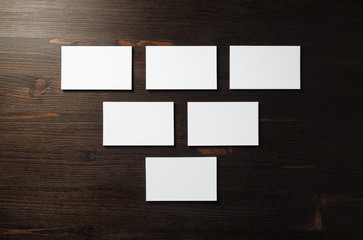 Blank white business cards on wooden background. Copy space for text. Flat lay.