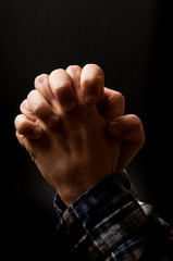 prayer - praying with Christian Catholic cross over black background like religion concept 