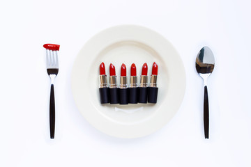 Lipsticks on white dish with fork and spoon on white