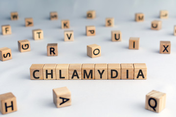 Chlamydia - word from wooden blocks with letters, parasitic bacterium chlamydia concept, random letters around, white  background