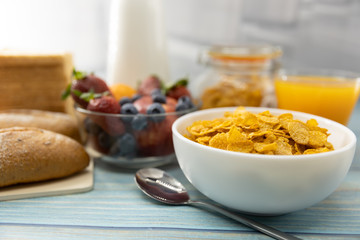 Healthy breakfast. bread, orange juice, strawberry, blueberries, milk and cereal in bowl on wooden table. Healthy food