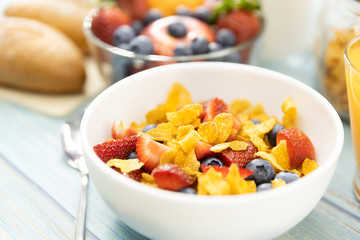 Healthy breakfast. bread, orange juice, strawberry, blueberries, milk and cereal in bowl on wooden table. Healthy food