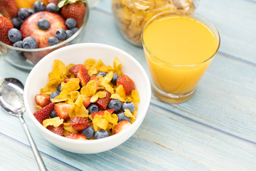 Healthy breakfast. bread, orange juice, strawberry, blueberries, milk and cereal in bowl on wooden table. Healthy food