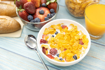 Healthy breakfast. bread, orange juice, strawberry, blueberries, milk and cereal in bowl on wooden table. Healthy food