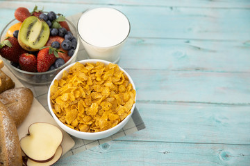 Healthy breakfast. bread, fruit, strawberry, blueberries, kiwi, milk in glass and cereal in bowl on mat and wooden table. Background Healthy food. with Copy space
