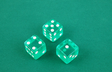 Three dices on green gaming table