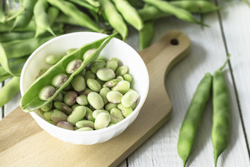raw beans. beans in a bowl and green beans on the table. beans closeup on white background.