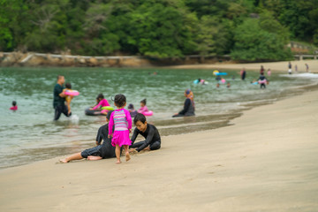 People at the beach of Teluk Batik. Teluk Batik Beach is located at Lumut and Sitiawan and looks out towards Pangkor Island, Perak's top beach destination.