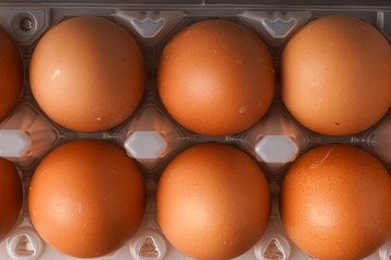 A carton of eggs on a wooden background