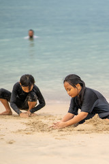 Fototapeta na wymiar Young asian kids are playing on the beach. Vacation and relax concept.