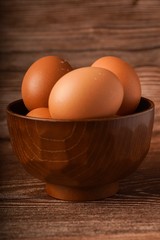 A carton of eggs on a wooden background