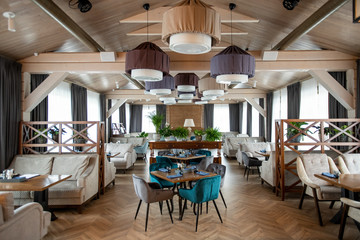 Interior of large hall of modern luxurious restaurant with served tables