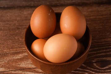 A carton of eggs on a wooden background