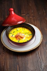 Fish soup in a pot with a red lid. catering menu