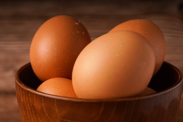 A carton of eggs on a wooden background
