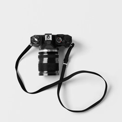 Black and sliver film camera with shoulder strap on isolated background