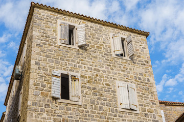 Fototapeta na wymiar building is made of stone with a tiled roof and wooden shutters on the windows