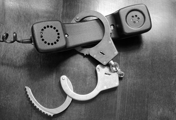 Obraz premium Telephone reciever with handcuffs close up