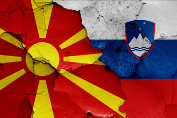 flags of North Macedonia and Slovenia painted on cracked wall