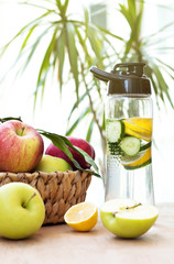 Healthy fruit water for sport, fitness. Bottle of water with lemon and fruits on wooden table