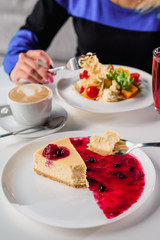 Cheesecake with berry jam on a white plate in the restaurant. close up. blure. space.