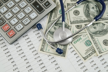 Cost of health care concept, stethoscope and calculator on document 