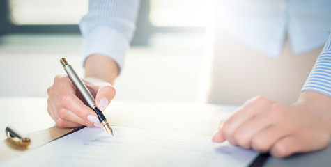 Business woman signing contract, making a deal.