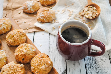 Cup with hot coffee and cookies on a white wooden table. Homemade baking.