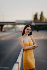 A young woman stands on a background of cityscape.
