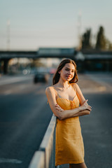 A young woman stands on a background of cityscape.