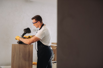 Maintenance man fixing furniture with a special equipment