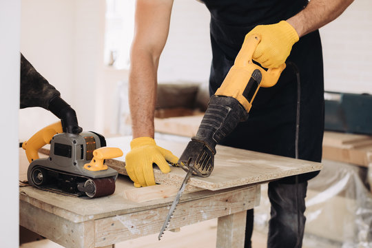 Maintenance Man Using A Power Saw To Fix Furniture