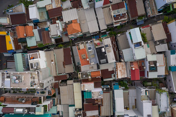 top down drone shot  over rooftops in urban residential area of major city in South East Asia. Shows terrace houses, iron roofs, alleyways 