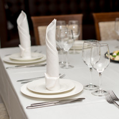 The white napkin nicely folded on the plates, serving a celebratory banquet.