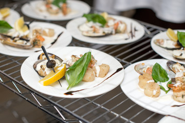Scallops, creatively arranged food on a white restaurant plate.