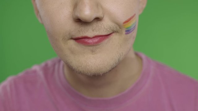 Bearded man with painted lips smiling on the camera. LGBT community. Transsexual