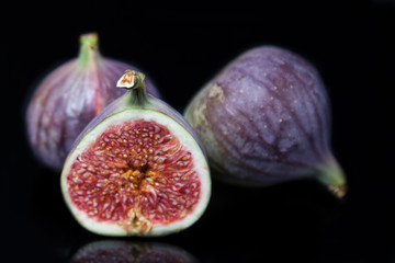  Ripened cut figs with reflection on black glass