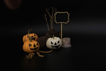 Decorated pumpkin lanterns, old timber, standing sign board and used candle in the dark. Image concept of Halloween festival.