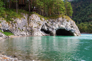 Altai, Russia. The bank of the Katun river with a natural grotto and an observation deck