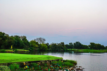 Flag marks the position of a golf hole for players in the evening.