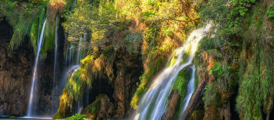 Breathtaking waterfalls panorama in Plitvice Lakes National Park, Croatia, Europe. Majestic view with turquoise water and sunset sunny beams, travel destinations background