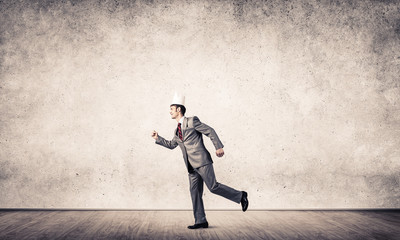 King businessman in elegant suit running in empty room with wooden floor