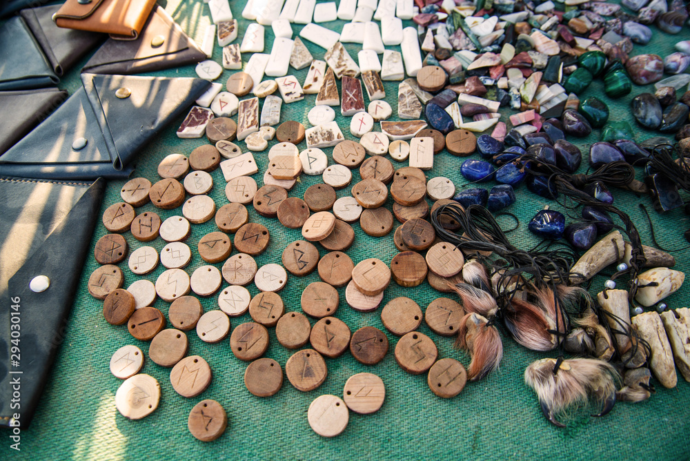 Wall mural wooden runes and semiprecious stones on a green background