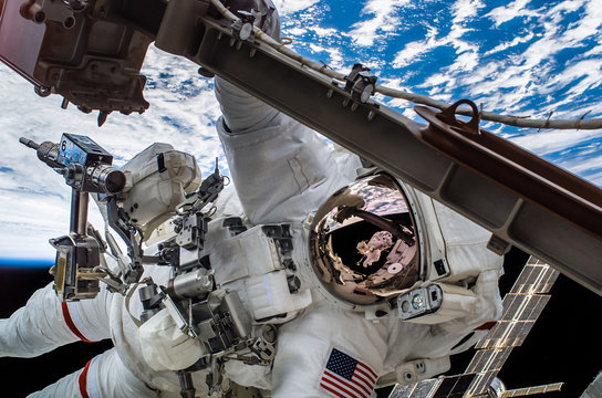 astronaut float in the space in weightlessness working on the spaceship near to planet earth Elements of this image furnished by NASA
